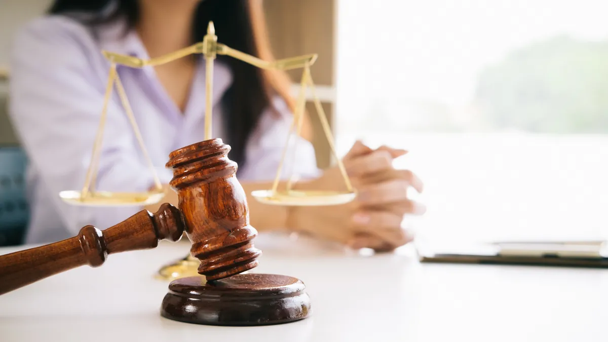 Martelo de juiz e balança da justiça sobre mesa de escritório